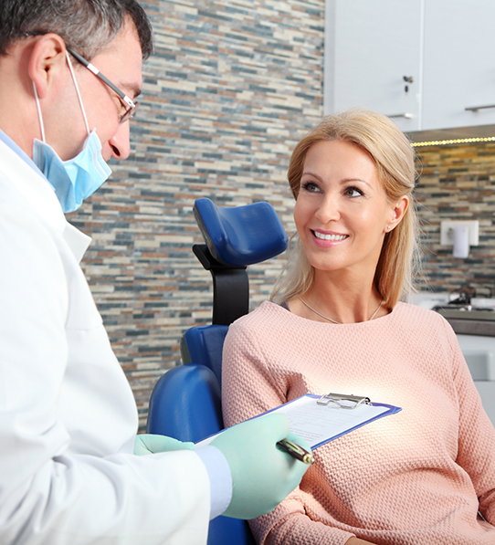 Male dentist in Frisco talking to female patient