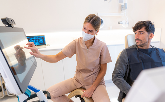 Dentist showing patient something on chairside monitor