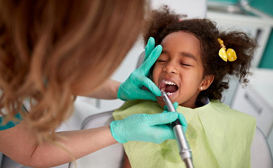 Little girl having teeth checked by dentist