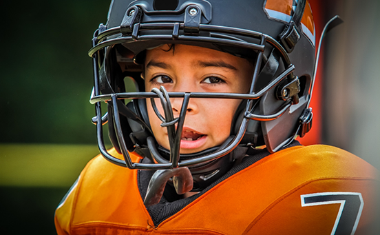 Little boy wearing football gear