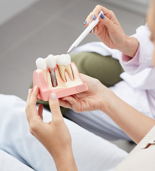 Patient holding model of dental implant in Frisco