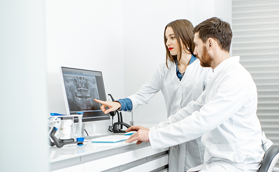 Two dentists looking at dental X-ray