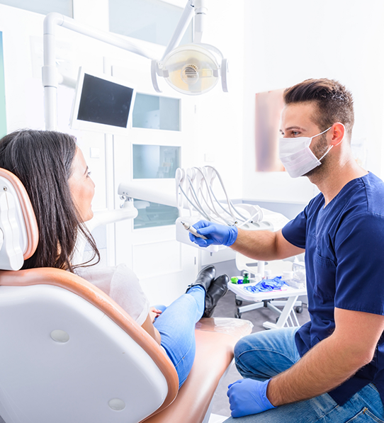 Dentist sitting next to dental patient