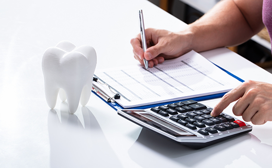 Filling out form and using calculator with tooth on table