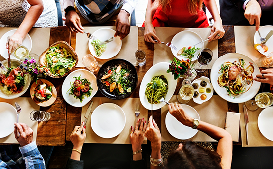 Multiple people filling plates at dinner table