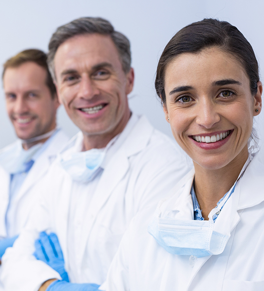 Dental team members standing in row and smiling