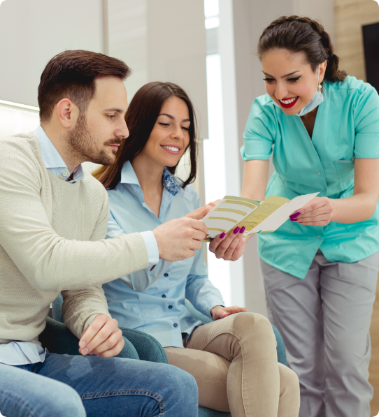 Dentist showing man and woman a pamphlet