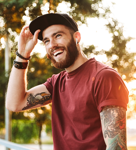 Man with hat standing outside and smiling