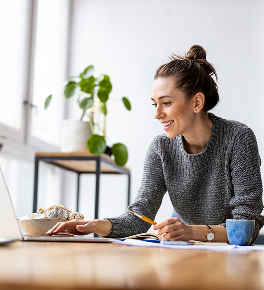 Woman sitting at table typing on laptop