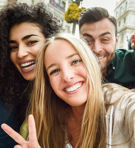 Two women and a man taking a selfie